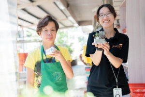 服務對象與教保員在創意手作課程中拿著植物盆栽合影