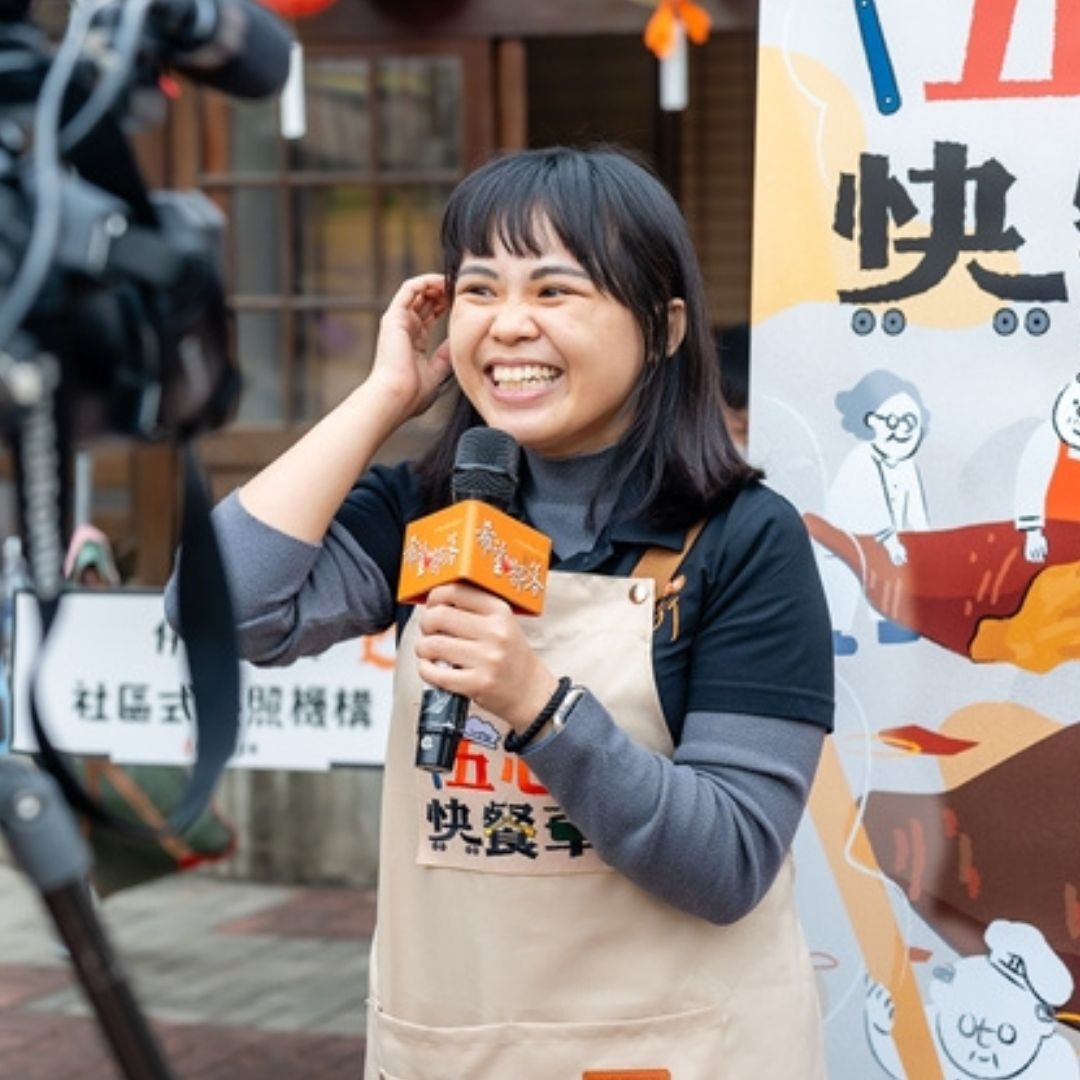 伊甸基金會員工在五心快餐活動中接受採訪並拿著麥克風